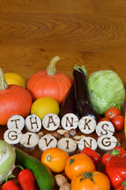 fruits and vegetables with burned wood showing the word thanksgiving.