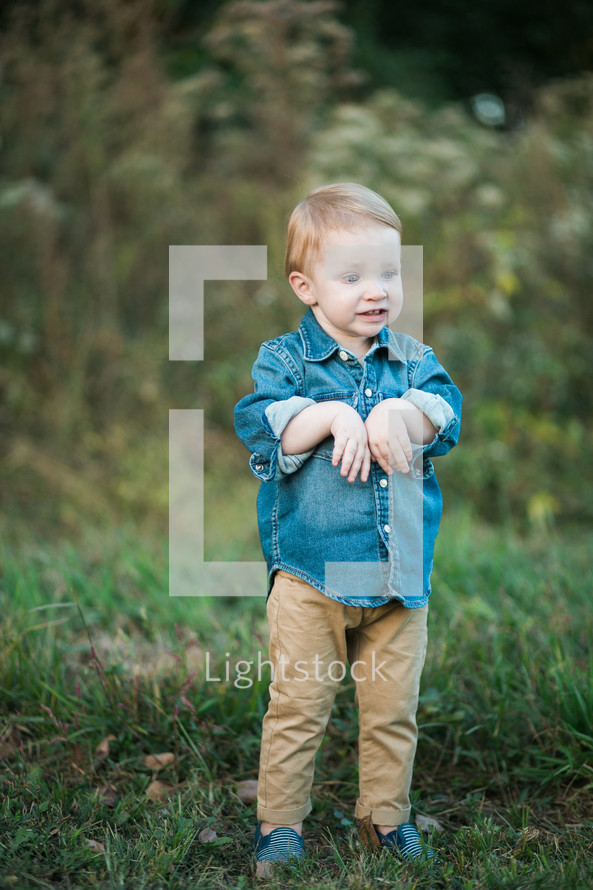 a toddler boy in the grass in fall 