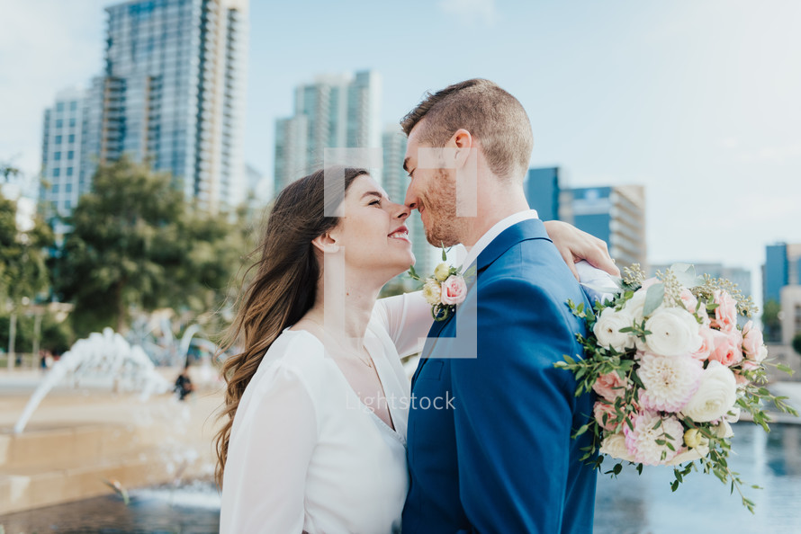 bride and groom in front of a city scene 