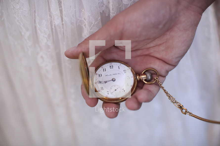 hand holding a pocket watch 