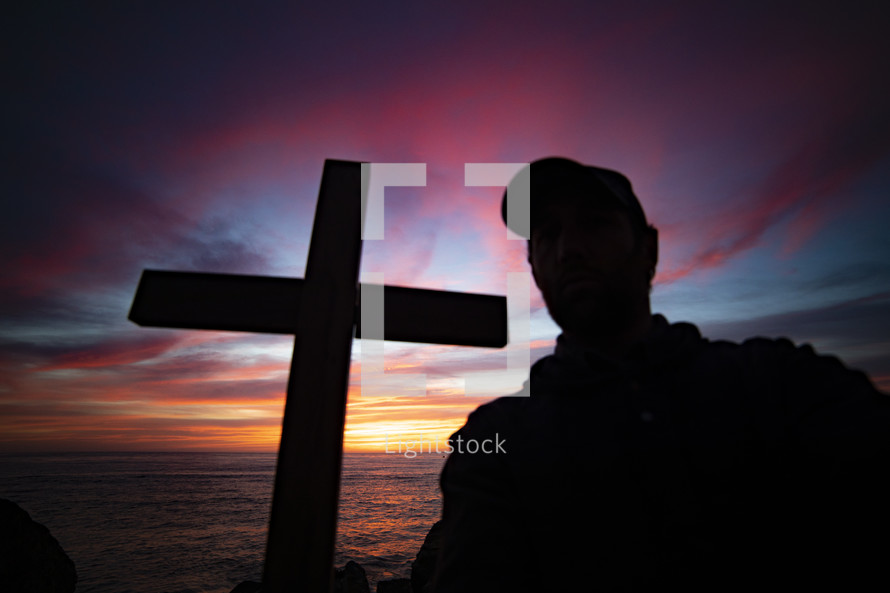silhouette of a man and cross at sunset 