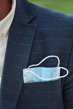 a businessman with a face mask in his pocket 