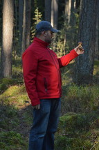man holding a mushroom in a forest 