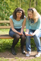 women praying together on a park bench 