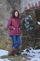 a woman standing outdoors in a coat in the snow 