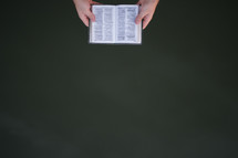 a man holding a Bible and negative space 