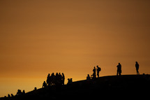 silhouettes of crowds on a hill 