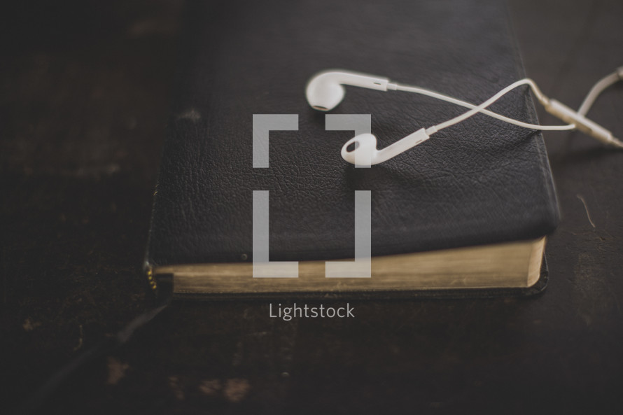 White ear buds on a Bible
