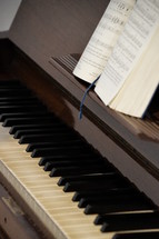 Piano up close with open songbook. 
