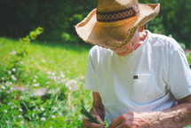 an elderly man tending a vegetable garden 