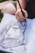 woman sketching on a sketch pad 
