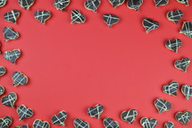 frame out of home made heart shaped cookies with chocolate on red background