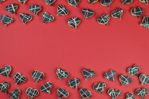 two ribbons out of home made heart shaped cookies with chocolate on red background