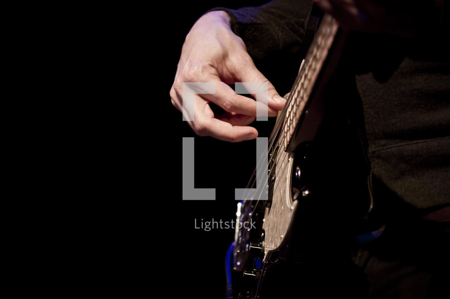 hand playing an electric guitar