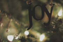 A joy ornament on the Christmas tree