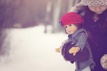 a little girl holding an American girl doll 