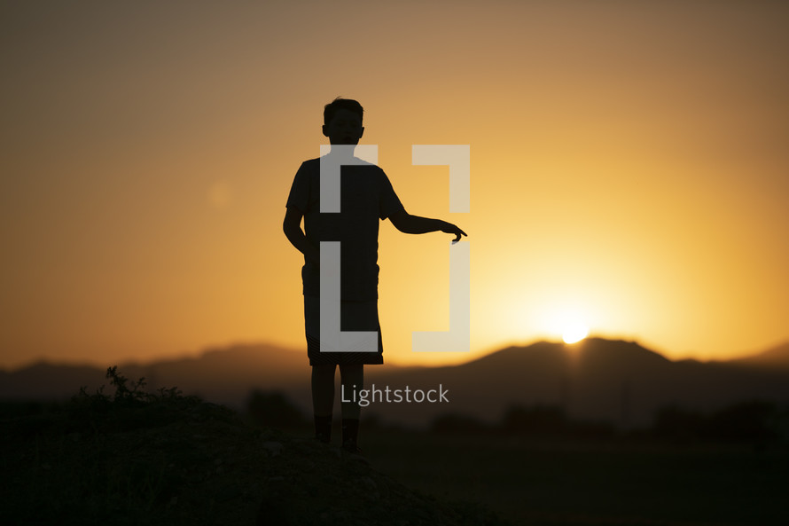 teen boy standing in warm sunlight 