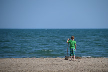 child on the beach with a shovel 