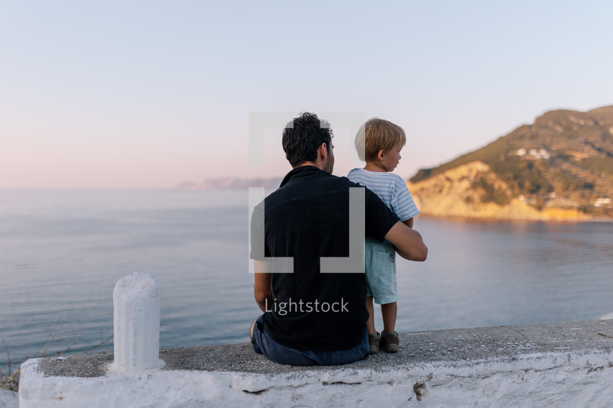 Father and son looking out over sea