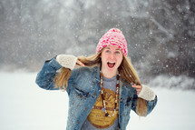 woman in a jean jacket standing in snow 