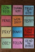 words about christian life behavior on notepads laying on a wooden table