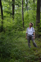 a woman looking up in a forest 