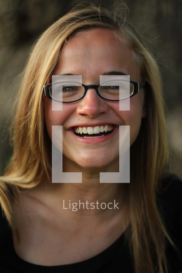 face of a smiling woman in glasses 