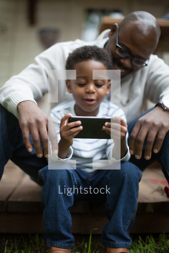 father and son looking at a cellphone screen