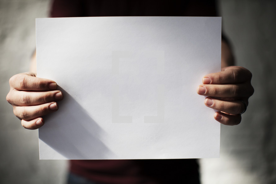 man holding a piece a blank white paper 