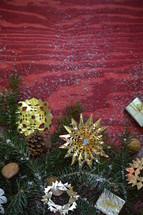 pine garland and gold tinsel ornaments on red wood 
