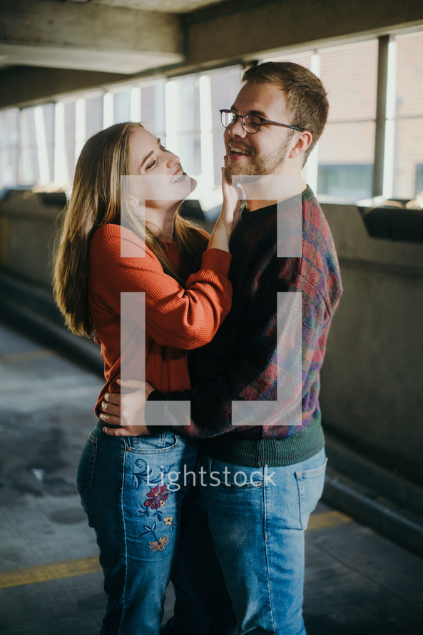 a couple hugging in a parking garage