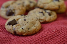 chocolate chips cookies on a red cloth
