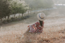 a woman sitting in a field 