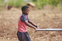 girl plowing a field in Africa