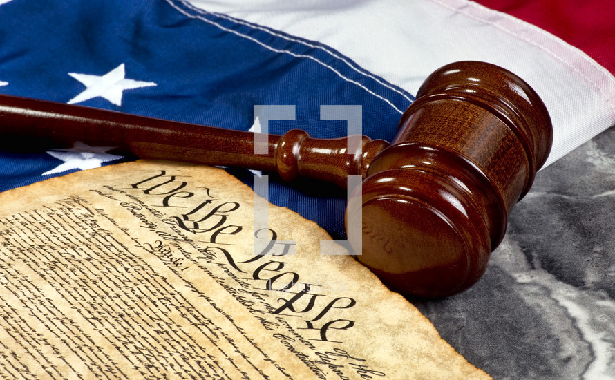 Wooden gavel on top of American flag and Bill of Rights document