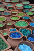 blue and green beads in pottery jars 