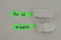 ripped open paper with the words HE IS RISEN