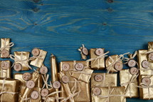 Border of advent calendar with twenty four golden presents on teal wood with negative space above