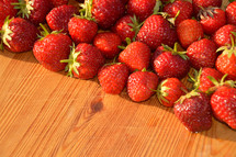 bright red fresh strawberries on a wooden board. 
