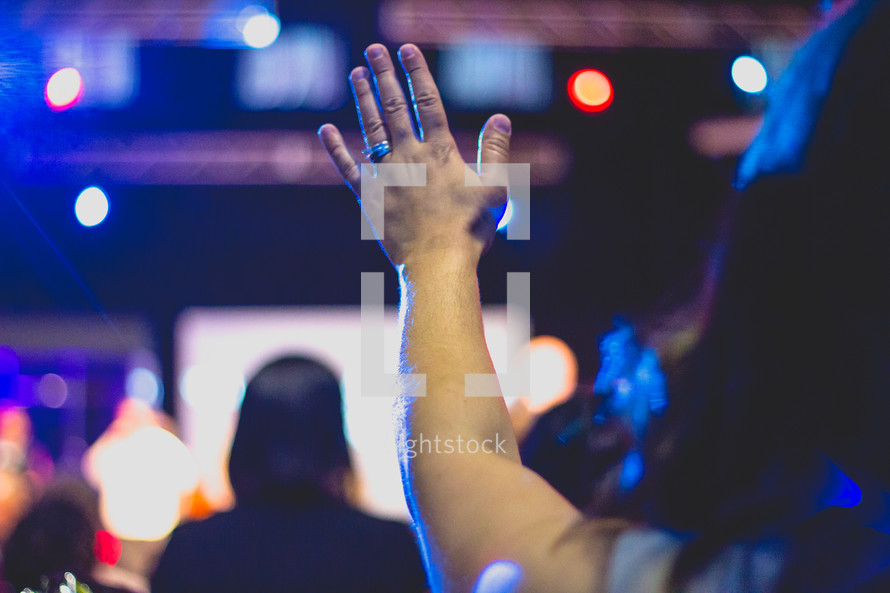a woman with raised hands during a worship service 