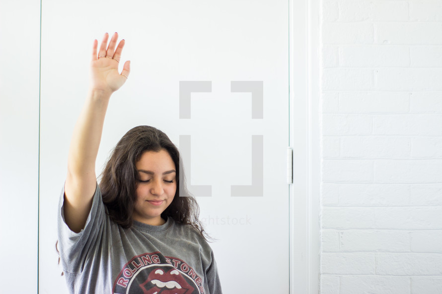 teen girl with hand raised 