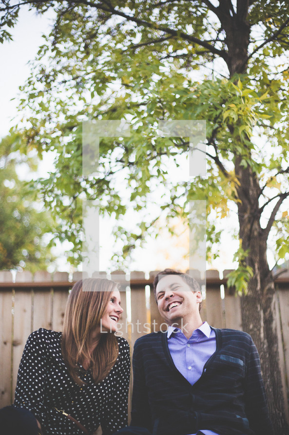 Couple laughing together outside.