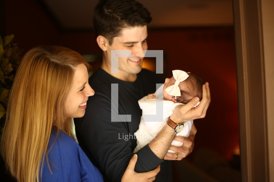 a mother and father holding their newborn baby 