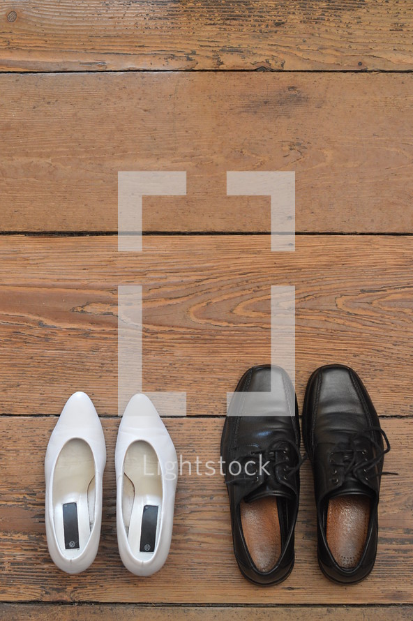 wedding shoes next to each other facing the same direction. 
