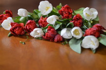 Red and white tulips on a wooden table. 
tulips, red, white, tulip, bloom, blossom, bright, spring, flower, flowers, creation, green, beauty, beautiful, nice, lovely, fine, pleasant, fair, pretty, plant, flourish, natural, leaves, leaf, green, mother's day, mother, mom, mum, mommy, March, April, May, bouquet, gift, present, thank you, thanks, floral, bunch, posy, wood, wooden, table, frame, edge, rim