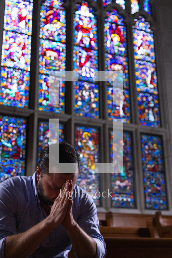a man praying alone in church 