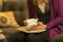 a young woman with a Bible and journal in her lap at a Bible study 