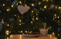 cookies and milk in front of a Christmas tree
