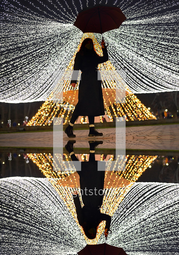 reflection of a woman holding an umbrella at night 