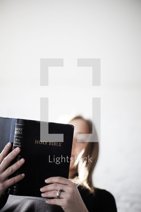 Low angle of a woman reading the Bible.